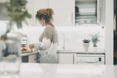 Rear view of woman sitting in bathroom