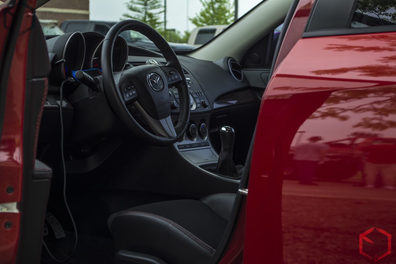 transportation, land vehicle, mode of transport, car, street, stationary, travel, road, bicycle, parking, parked, vehicle, red, vehicle interior, day, part of, car interior, parking lot, on the move, sunlight