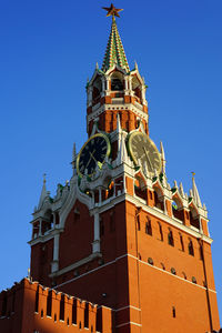 Low angle view of clock tower against blue sky