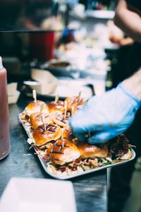 Close-up of man preparing burger on tray at concession stand