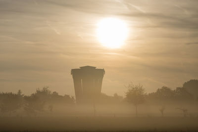 Silhouette of water tower at sunrise