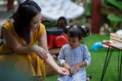 Smiling woman with daughter playing at park