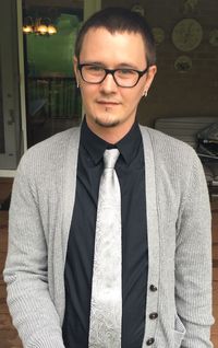 Portrait of businessman wearing eyeglasses while standing against door