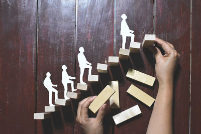 Close-up of hand holding text on wood