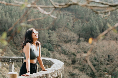 Portrait of young woman sitting on rock