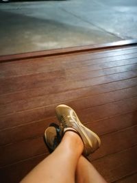Low section of woman sitting on hardwood floor