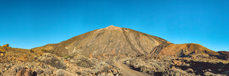 View of rocky mountain against blue sky