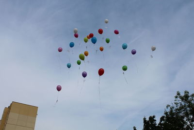 Low angle view of balloons flying against sky