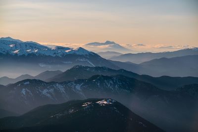 Scenic view of snowcapped mountains against sky during sunset