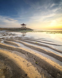 Scenic view of beach against sky during sunset