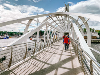 Rear view of people walking on footbridge