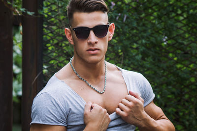 Portrait of young man wearing sunglasses standing outdoors