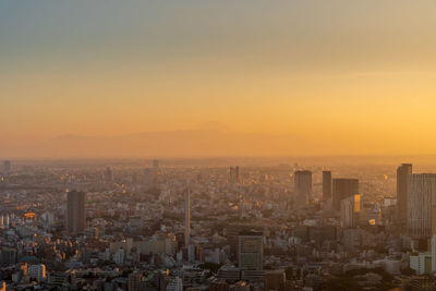 High angle view of modern buildings against sky during sunset