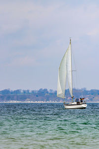 Sailboat sailing on sea against sky