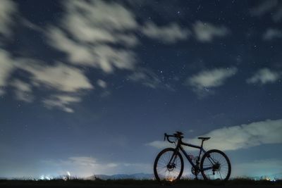 Bicycles against sky at night