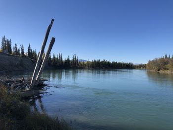 Scenic view of lake against clear blue sky