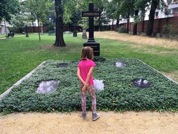 Full length rear view of girl standing in cemetery