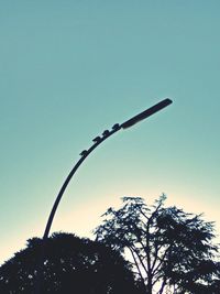 Low angle view of trees against clear blue sky