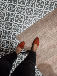 Low section of man standing on tiled floor