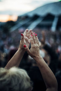 Rear view of woman applauding while standing outdoors