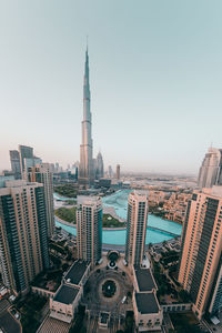 Aerial view of buildings in city against clear sky