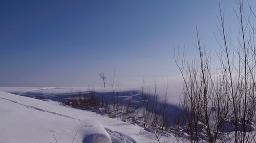 Scenic view of landscape against clear blue sky during winter