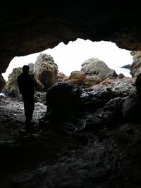 Rear view of man standing in cave