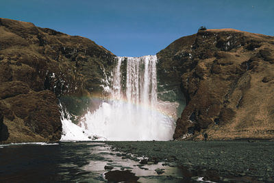 Scenic view of waterfall against sky