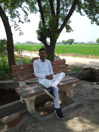 Portrait of young man sitting on bench