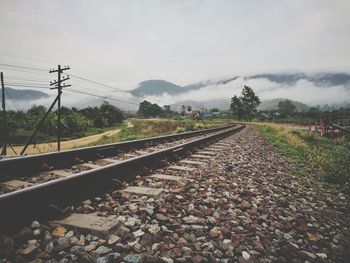 Railroad track amidst trees against sky