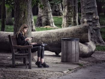 Woman sitting on bench in park