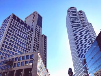 Low angle view of modern buildings against blue sky