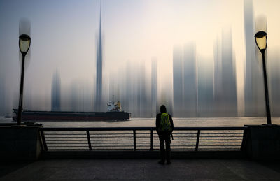 Rear view of man standing on street in city