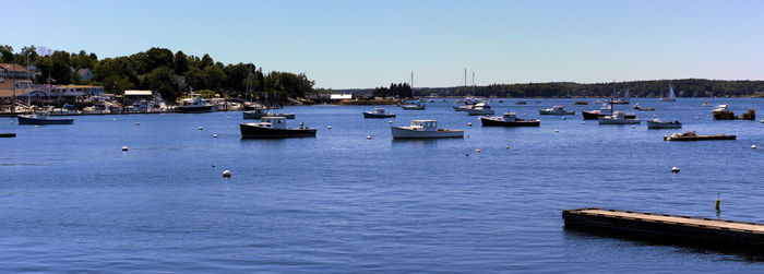 Boats moored in sea against clear sky