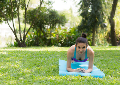 Portrait of smiling young woman exercising on field