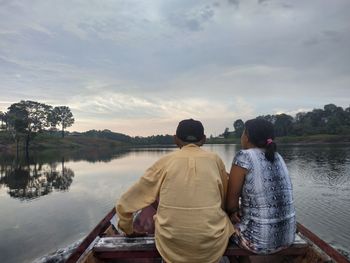 Rear view of couple on lake against sky