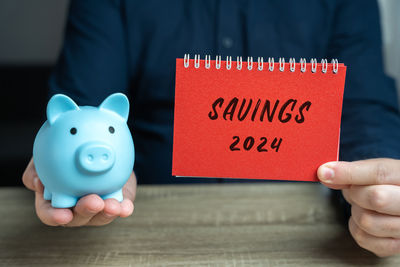 Midsection of man holding piggy bank