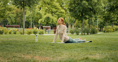 Yogi outdoors, stretching back in the park. raining and stretching muscles, tendons, bones