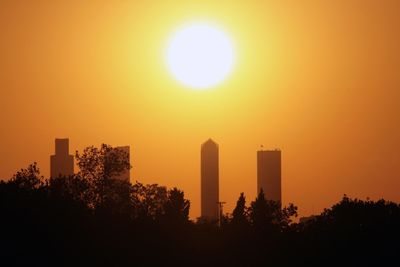 Silhouette buildings against sky during sunset