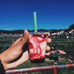 Midsection of person holding hands against clear blue sky