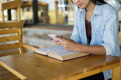 Woman using mobile phone on table