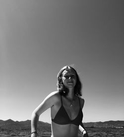 Portrait of woman standing in sea against clear sky