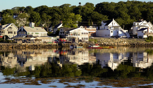 Houses by lake against sky