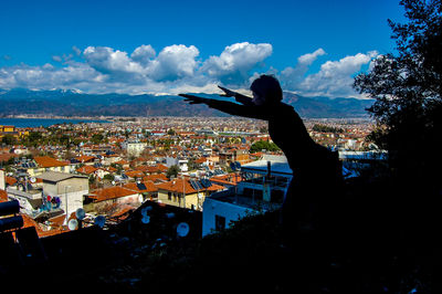 Man and cityscape against sky