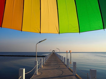 Empty pier at sea against clear sky during sunset