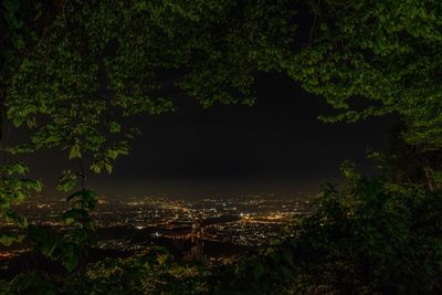 Illuminated cityscape against sky at night