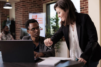 Smiling businesswoman talking with colleague in clinic