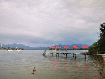 Scenic view of swimming pool by lake against sky