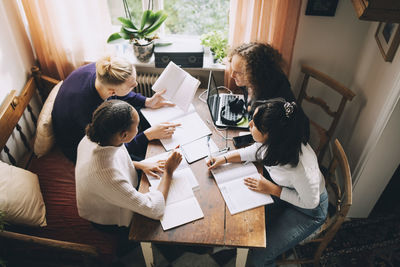 High angle view of people sitting on table