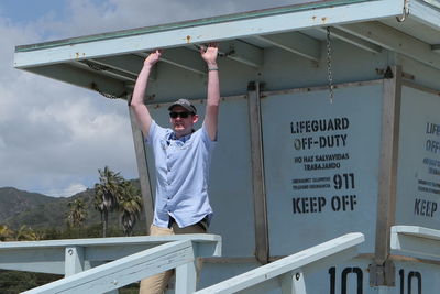 Portrait of man standing at lifeguard hut